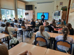 Policjant prowadzi pogadankę z dziećmi w klasie.