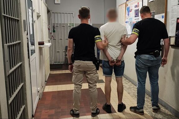 Policjanci prowadzą zatrzymanego.