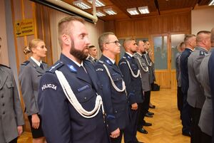 Sala odpraw wieluńskiej jednostki Policji, w której odbywa się Święto Policji. Pododział  policjantów stoi w mundurach wyjściowych .