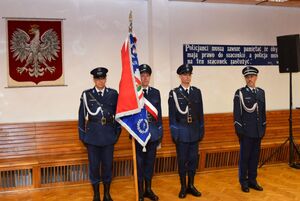 Sala odpraw wieluńskiej jednostki Policji. Poczet sztandarowy oraz dowódca uroczystości.