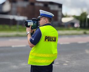 Policjant mierzy prędkość poruszających się pojazdów.