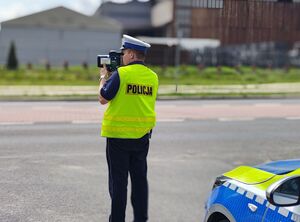 Policjant mierzy prędkość na drodze.