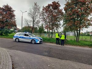 Dwoje policjantów kamizelkach odblaskowych wraz z rowerzysta