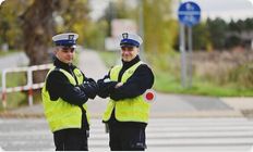 Policjanci w kamizelkach odblaskowych.